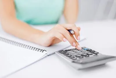 woman using calculator to calculate dental insurance costs